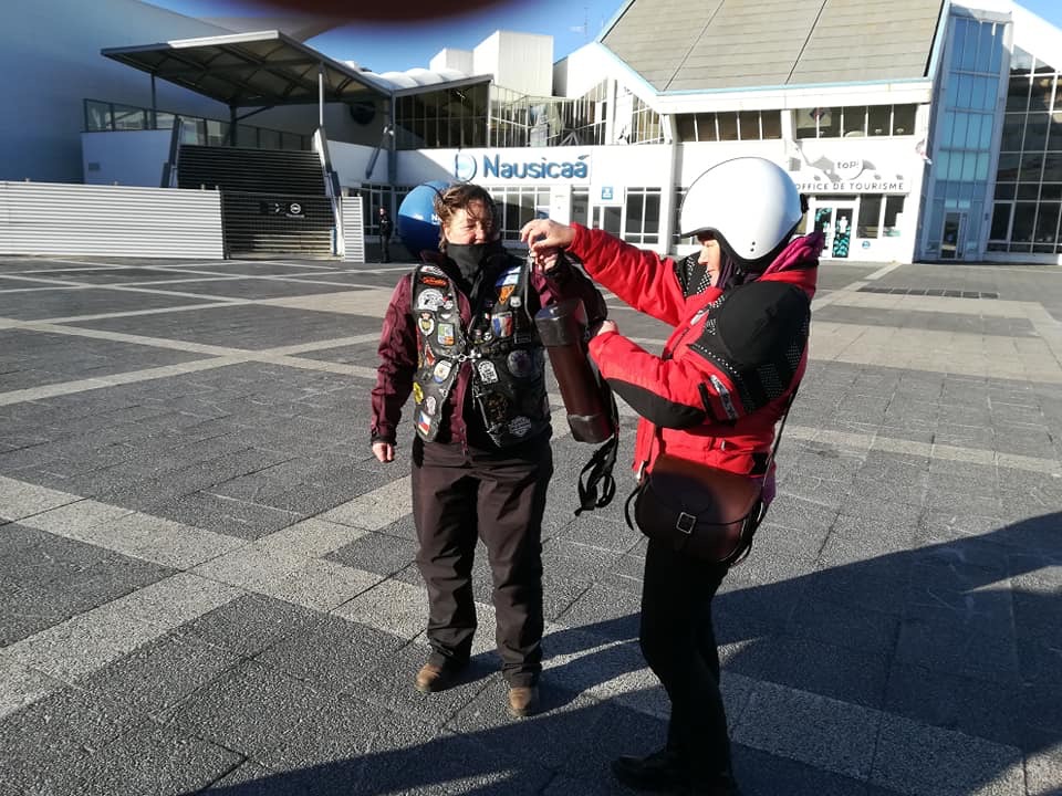 Two women motocyclists handing over baton in France for the WRWR