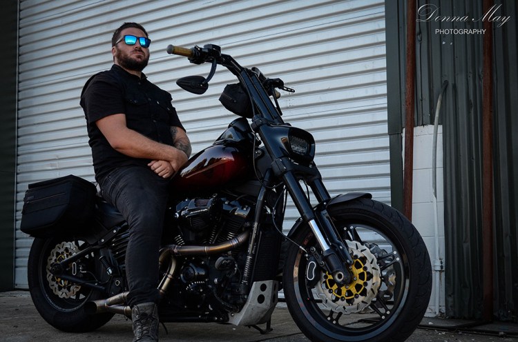 A photograph of a man sat on his motorbike