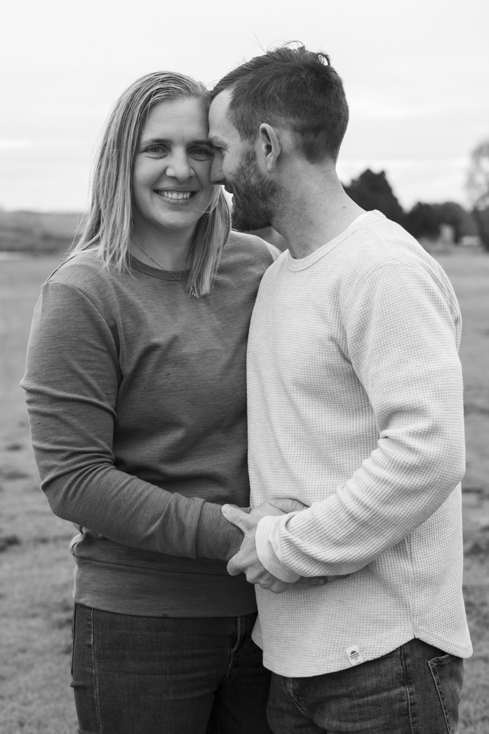 A black and white portrait photo of a couple sharing an intimate moment during a photoshoot. Taken by Te Awamutu, Waikato based photographer Donna from Donna May Photography.