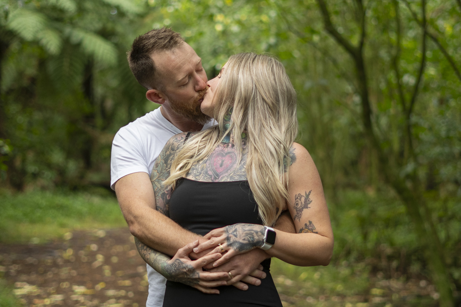 A portrait photo of a couple kissing in a forest. Taken by Te Awamutu, Waikato based photographer, Donna from Donna May Photography.
