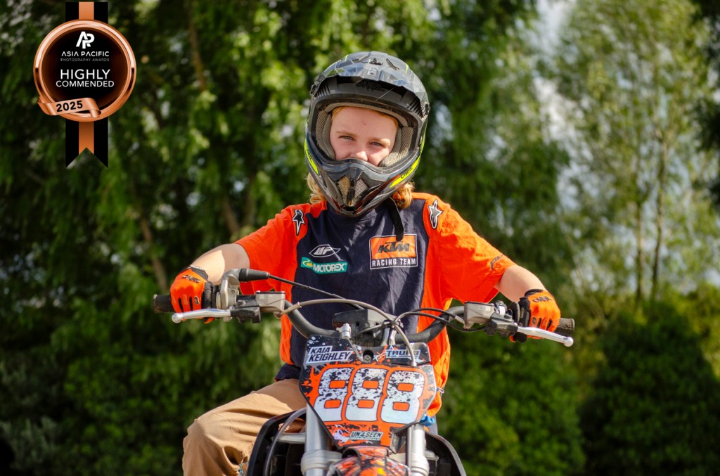 A colorful motorbike portrait photo of a girl on her KTM dirt bike. Taken by Te Awamutu, Waikato based photographer, Donna from Donna May Photography. This photo was highly commended in the 2025 Asia Pacific Awards.