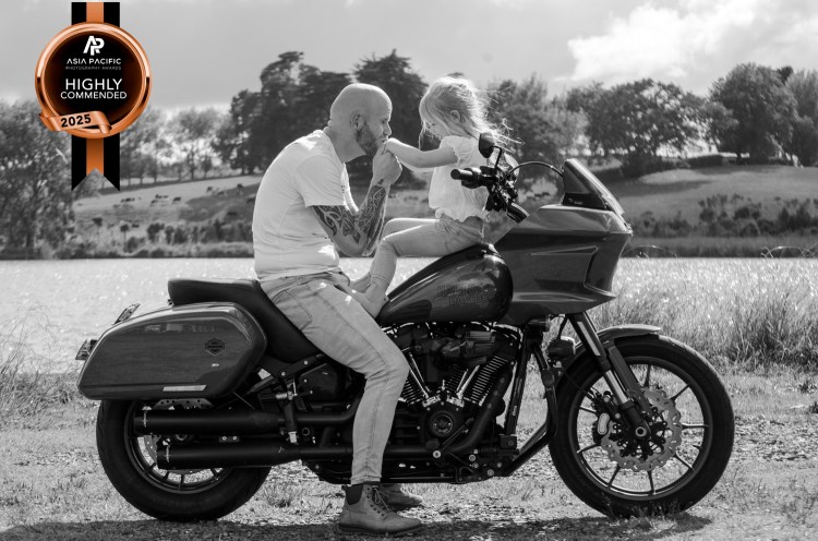 A black and white motorbike portrait photograph of a dad and his daughter. Taken by Te Awamutu, Waikato based, family photographer, Donna from Donna May Photography. This image was highly commended in the 2025 Asia Pacific Awards.