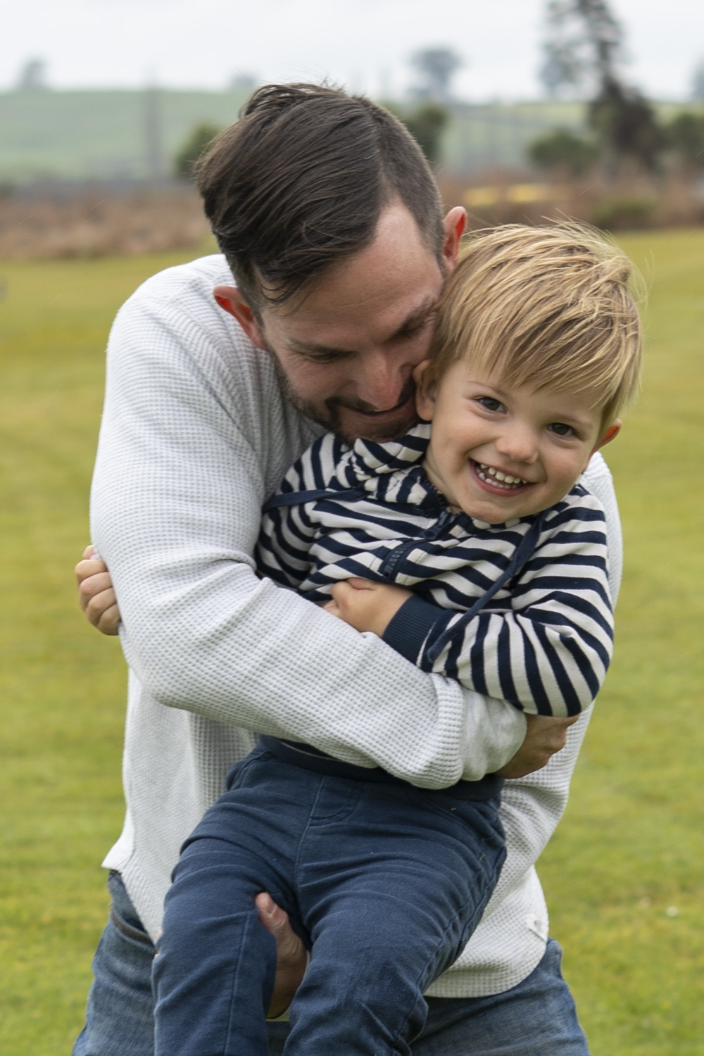 A portrait photo of a young dad hugging his son. Taken by Te Awamutu, Waikato based photographer, Donna form Donna May Photography