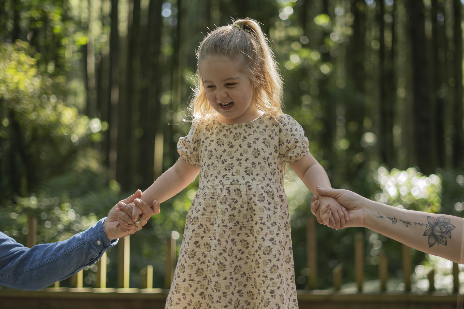Children's family portrait photo of a little girl holding her parents hands. Taken by Te Awamutu, Waikato based photographer, Donna from Donna May Photography.