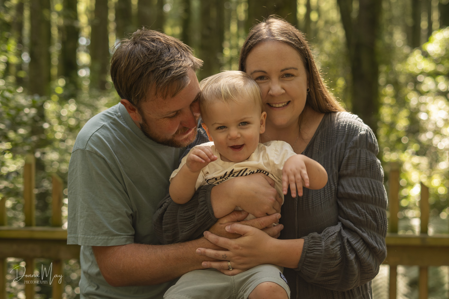 Family portrait photo of a young family hugging in a forest. Taken by Te Awamutu, Waikato based photographer, Donna from Donna May Photography.
